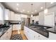 Bright kitchen features stainless appliances, white cabinetry, granite counters and backsplash, and a spacious island at 9921 N Wind River Run, McCordsville, IN 46055