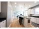 Bright kitchen with stainless appliances, white cabinetry, granite counters, and spacious island with barstool seating at 9921 N Wind River Run, McCordsville, IN 46055