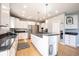 The bright kitchen features white cabinetry, granite countertops, stainless steel appliances, and a spacious island at 9921 N Wind River Run, McCordsville, IN 46055