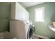 Laundry room featuring a washing machine and storage cabinets with a window at 9921 N Wind River Run, McCordsville, IN 46055