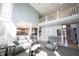 Open-concept living room featuring neutral tones, plush seating, and a view of the upper level loft at 9921 N Wind River Run, McCordsville, IN 46055
