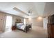 Spacious main bedroom featuring a tray ceiling, ceiling fan, and great natural light from large windows at 9921 N Wind River Run, McCordsville, IN 46055