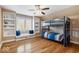 Cozy bedroom featuring a bunk bed, hardwood floors, built-in shelving, and natural light at 10249 Southwind Dr, Indianapolis, IN 46256