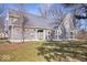 Charming gray home with manicured lawn, mature trees, and inviting entryway at 10249 Southwind Dr, Indianapolis, IN 46256