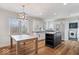 Open kitchen featuring white cabinets, stainless appliances, and an island with shelving at 10249 Southwind Dr, Indianapolis, IN 46256