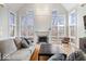 Well-lit living room with a fireplace, hardwood floors, large windows, and a grey sofa at 10249 Southwind Dr, Indianapolis, IN 46256