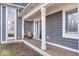 Charming covered porch with wood flooring, white columns, and a sliding glass door for easy outdoor living at 10249 Southwind Dr, Indianapolis, IN 46256