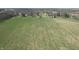 Expansive aerial shot of a grass-covered lot with old barns and homes in the distance at 10624 N 200 W, Alexandria, IN 46001