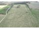 Expansive aerial shot of a large, grass-covered lot with a white gravel road and small building at 10624 N 200 W, Alexandria, IN 46001
