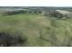 An aerial view shows a field with scattered trees and open grass areas at 10624 N 200 W, Alexandria, IN 46001