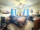 Bedroom features a ceiling fan and natural light from windows dressed with blue curtains at 10624 N 200 W, Alexandria, IN 46001