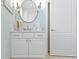 Stylish bathroom vanity with white cabinetry, subway tile backsplash, and a round mirror at 10744 Eldorado Cir, Noblesville, IN 46060
