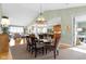 Open-concept dining room with chandelier and views to kitchen and living areas at 10744 Eldorado Cir, Noblesville, IN 46060