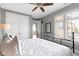 Bright main bedroom with a black metal bed frame, plantation shutters and carpet flooring at 10744 Eldorado Cir, Noblesville, IN 46060