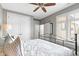 Comfortable bedroom with ceiling fan, white walls, natural light, and a sliding barn door at 10744 Eldorado Cir, Noblesville, IN 46060