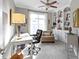This well-lit office features built-in bookshelves, a ceiling fan and a comfortable chair at 10744 Eldorado Cir, Noblesville, IN 46060