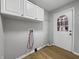 Bright laundry room with modern fixtures, white cabinets, and a rear exit door at 110 Pleasant Run Dr, Markleville, IN 46056
