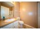 Bathroom with tan walls and tile flooring, a white sink and toilet, and a mirror at 123 Bridgemor Ln, Mooresville, IN 46158