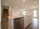 Open concept kitchen features quartz counters, stainless appliances, and gray wood floors at 1265 Fleming Dr, Greenfield, IN 46140