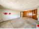 A large living room with carpet floors, wood paneled wall and built-in storage at 1303 S D St, Elwood, IN 46036