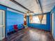 Bright blue living room featuring wood flooring and a ceiling fan at 1303 S D St, Elwood, IN 46036