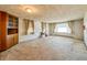 An empty living room with windows, a built-in cabinet and carpet flooring at 1303 S D St, Elwood, IN 46036