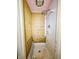 A shower featuring ceramic tiles with dated fixtures, with wallpaper and a metal storage rack at 1303 S D St, Elwood, IN 46036