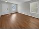 Neutral empty room featuring hardwood floors, white walls, a double window, and a white door at 15503 Sandlands Cir, Noblesville, IN 46060