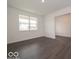 Open-concept living room with dark hardwood floors and large windows at 1618 Trichel Dr, Greenwood, IN 46143
