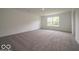 Bright, spacious living room features plush carpeting and abundant natural light from a large window at 1618 Trichel Dr, Greenwood, IN 46143