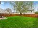 Lush backyard featuring a large tree and wooden privacy fence creating a serene outdoor space at 2011 Blue Pine Ln, Indianapolis, IN 46231