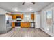 Well-lit kitchen equipped with stainless steel appliances, wood cabinets, and hardwood floors at 2011 Blue Pine Ln, Indianapolis, IN 46231