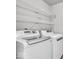 Clean laundry area featuring modern white washer and dryer units with overhead shelving at 2011 Blue Pine Ln, Indianapolis, IN 46231