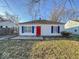 Lovely home with blue shutters and a red front door set against a green lawn at 2207 E Dudley Ave, Indianapolis, IN 46227