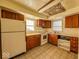 A kitchen has wood cabinets, a white refrigerator and stove, and vinyl tile flooring at 2207 E Dudley Ave, Indianapolis, IN 46227