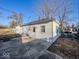 Rear view featuring the home's exterior, including a back door and concrete patio at 2207 E Dudley Ave, Indianapolis, IN 46227