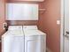 Functional laundry room featuring white washer and dryer and extra overhead storage at 2257 Grand Fir Dr, Greenwood, IN 46143