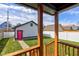 Backyard of home with a fenced-in yard and a detached garage with a bright pink door, viewed from a wooden porch at 2432 N Talbott St, Indianapolis, IN 46205