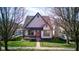 Exterior view of this charming two-story home with a red door, covered porch, and well-maintained lawn at 2432 N Talbott St, Indianapolis, IN 46205