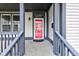 Close-up of the front porch highlighting the vibrant red door and charming architectural details at 2432 N Talbott St, Indianapolis, IN 46205