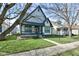 Inviting two-story home featuring a covered porch, well-maintained lawn, and mature trees at 2432 N Talbott St, Indianapolis, IN 46205