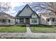 Charming two-story home with a covered porch, landscaped yard, and a vibrant red front door at 2432 N Talbott St, Indianapolis, IN 46205