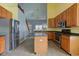 Kitchen with stainless steel appliances, wooden cabinets and island, and open access to the living room at 2432 N Talbott St, Indianapolis, IN 46205