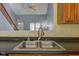 Close-up of the stainless steel sink and faucet with a view into the living area of this open-concept house at 2432 N Talbott St, Indianapolis, IN 46205