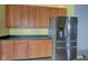 A kitchen featuring stainless steel refrigerator and wooden cabinets with black countertops, great for cooking at 2432 N Talbott St, Indianapolis, IN 46205