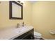 Powder room with a stylish dark vanity, stone countertop, and mirror at 3029 Oberlin Ct, Indianapolis, IN 46268