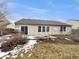 Backyard with a deck, lawn, and glimpses of surrounding greenery on a partially snow-covered day at 307 Beacon Point Ln, Fortville, IN 46040