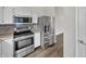 Stainless steel appliances, including a refrigerator and range, complement white cabinetry at 307 Beacon Point Ln, Fortville, IN 46040