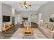 Bright living room with hardwood floors, neutral paint, ceiling fan, and comfortable furnishings at 307 Beacon Point Ln, Fortville, IN 46040