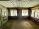 Enclosed porch with multiple windows, green walls, and door to the outside at 3120 Central Ave, Anderson, IN 46016